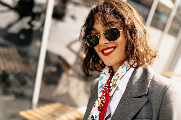 工作阳光下城市里可爱微笑的波浪短发女孩的特写户外写真女士微笑问题