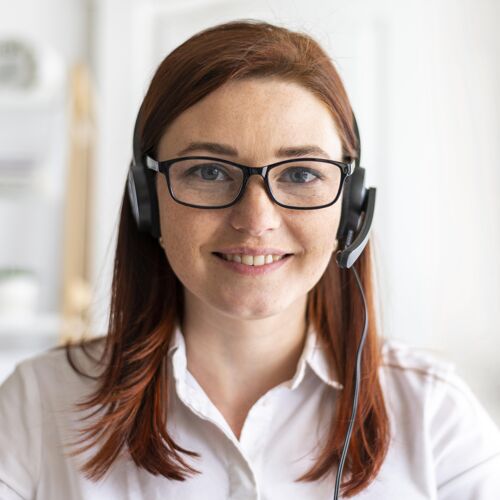 技术工作中的肖像女人有视频通话耳机女性微笑