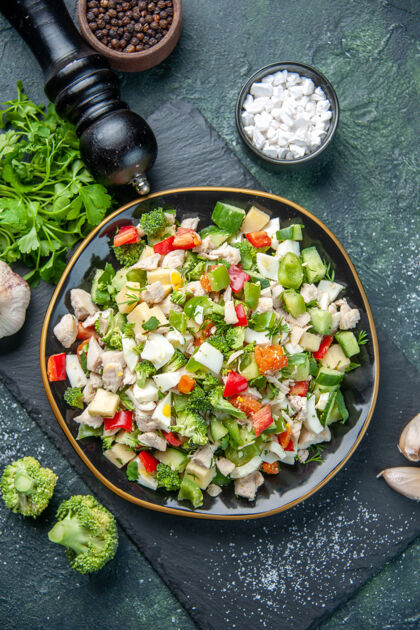 里面顶视图美味蔬菜沙拉内盘深蓝色背景色美食午餐餐厅健康减肥餐蔬菜食物胡椒