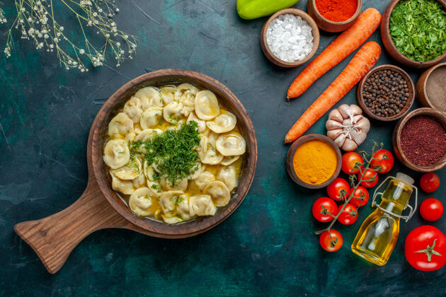 盘子俯瞰美味的水饺 用蔬菜和不同的调味料放在深绿色的面上 食物配料产品面团肉配料饺子膳食
