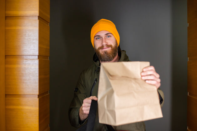 微笑高加索人送人搬运箱内食物的箱子 在门口交给顾客会议期间送货服务工作顾客在线