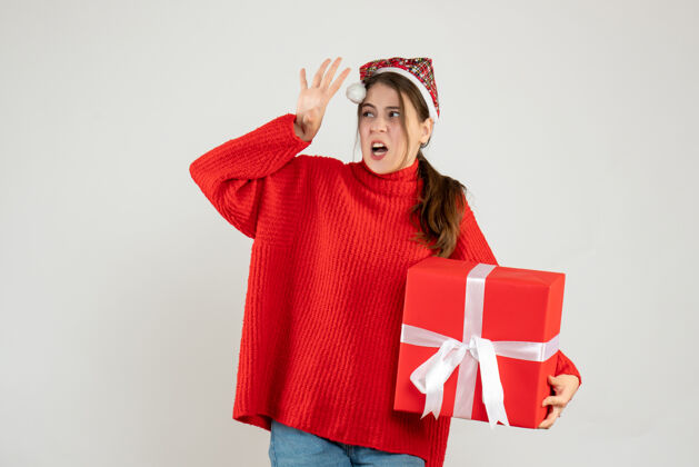 圣诞老人正面图愤怒的戴着圣诞帽的女孩拿着礼物站着礼物站着快乐