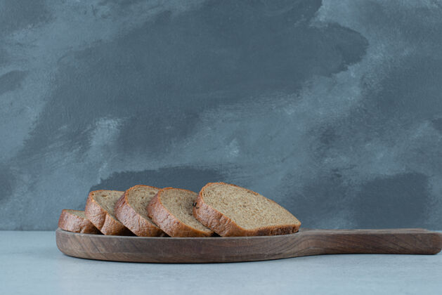 有机木板上的黑面包片健康切片石头