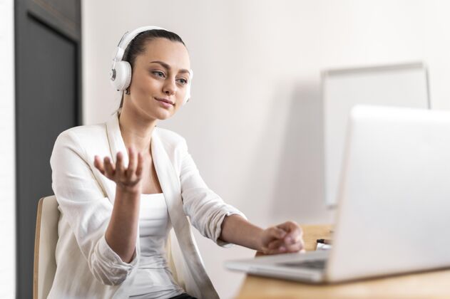 办公室工作中的肖像女性有视频通话女性耳机工作