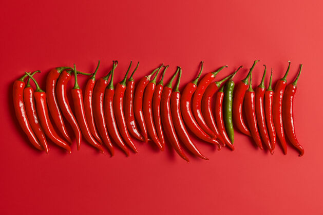 辛辣在生动的背景上垂直排列的红辣椒从市场或花园里收获的新鲜蔬菜带有复制空间的设计横幅平面视图食物和营养概念单色观点明亮