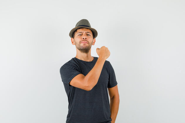 专业年轻男子戴着t恤帽子握紧拳头 看起来很自信商务摄像头严肃表演