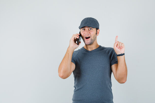 小戴着t恤帽的年轻男性在打手机时发现了一个好主意接听电话同时幼儿