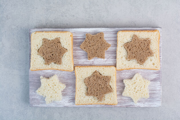 形状木盘上星形和方形的黑白面包片谷类糕点面包房