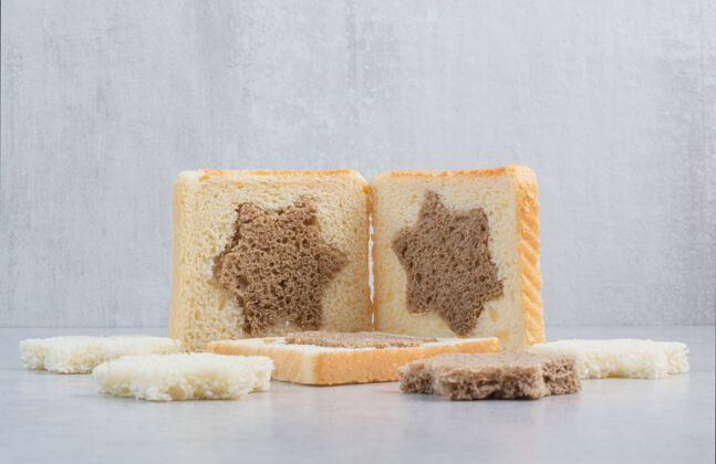 切星型和方形的黑白面包片放在石桌上面包面包房方形