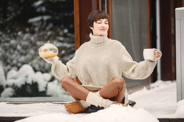 坐着穿着白毛衣 喝茶的女人的特写肖像季节快乐毛衣