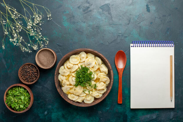 盘子俯瞰美味的饺子汤与绿色和不同的调味料对暗面汤面团蔬菜食品面团午餐汤