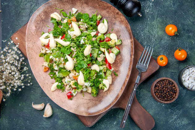 蔬菜顶视图美味的蔬菜沙拉在深蓝色背景的盘子里烹饪晚餐午餐健康适合厨房餐厅的颜色沙拉午餐晚餐