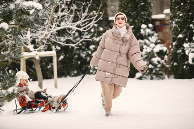 孩子一家人穿着冬装在雪林里度假下雪乐趣父母