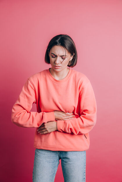腹部女人穿着休闲毛衣就背着肚子疼带着痛苦的鬼脸 感觉突然的经期抽筋 妇科概念女孩抽筋伤害