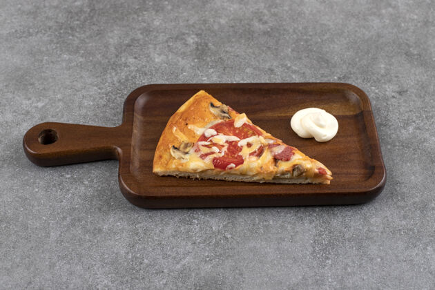 晚餐石桌上放着一块切好的比萨饼木板美食奶酪有机