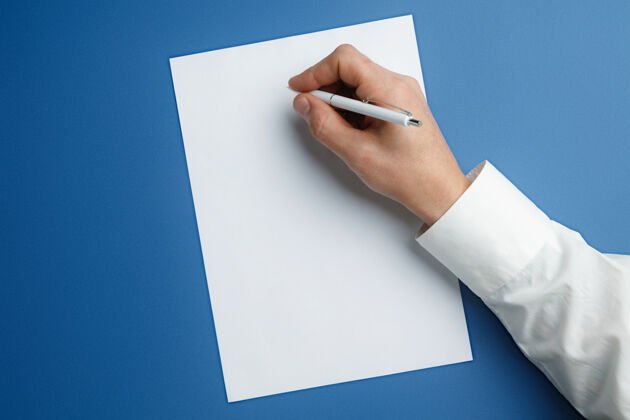 黑色男性手持钢笔 在蓝色的空纸上写字联系人工人手指