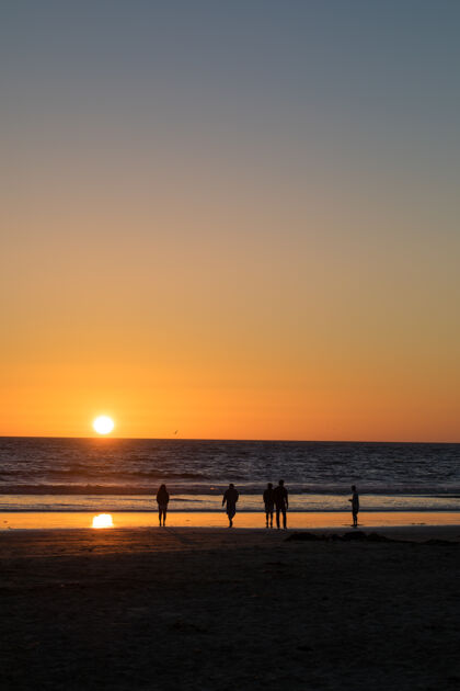 黄昏黄金时段五个人在海边散步黎明海岸线海滩