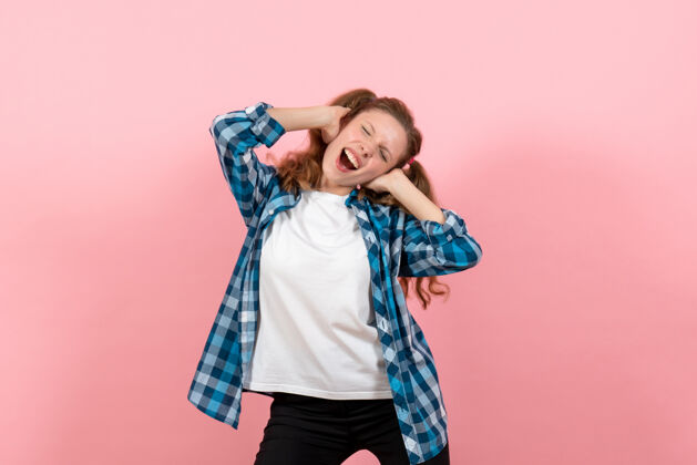 情感正面图身着格子衬衫的年轻女性在粉色背景上摆姿势模特年轻女性情感童装衬衫肖像漂亮