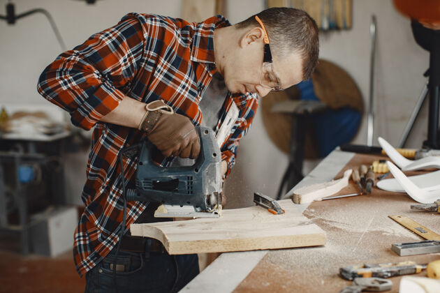 木工使用圆锯的工匠金属男木板