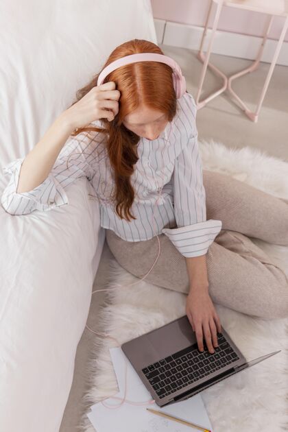 女人戴着耳机在家工作的女人模型笔记本电脑女性