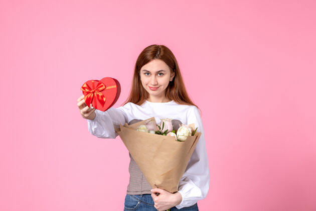 人正面图：年轻女性 带鲜花 在粉色背景上作为妇女节礼物 水平三月平等爱性感女性约会玫瑰玫瑰礼物礼物