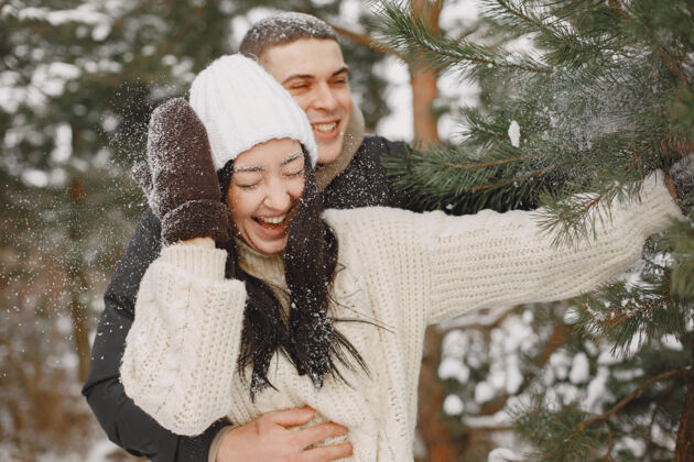 雪一对情侣在雪林中散步的生活方式照片毛衣关系女孩