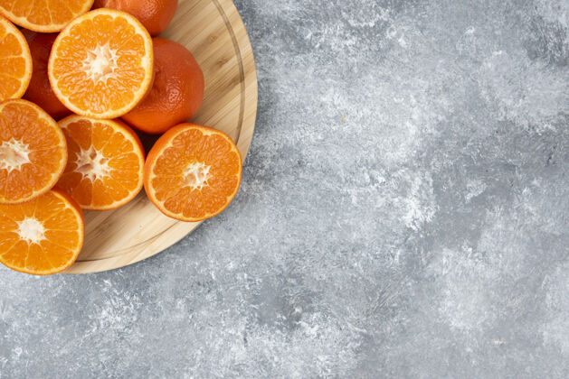 柑橘把新鲜多汁的橙子切片放在木盘里有机组平面