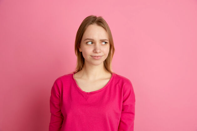 广告怀疑 不确定粉红工作室里的白人年轻女子肖像工作面部女人