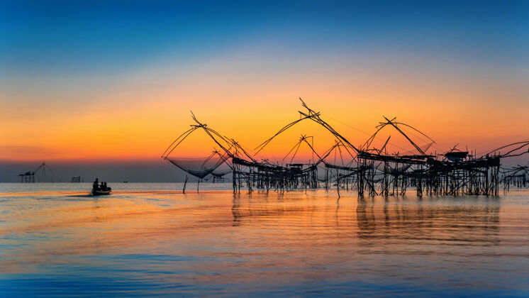 黎明美丽的日出和渔网浸在pakpra在phatthalung 泰国捕鱼自然日出