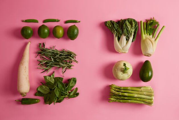 室内食品和新鲜蔬菜绿芦笋 青柠 鳄梨 白萝卜 玫瑰梅 罗勒分离在粉红色表面产品或配料 使有机健康餐节食 农业扁豆玫瑰蔬菜