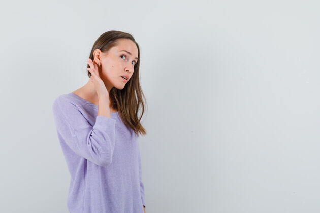 化妆年轻的女性穿着淡紫色的衬衫听着 看上去很专注女性自信衬衫
