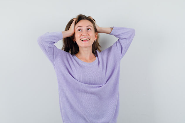 抱着一位身穿淡紫色上衣的年轻女性 手放在头上 笑着 看起来很开心女士优雅衬衫