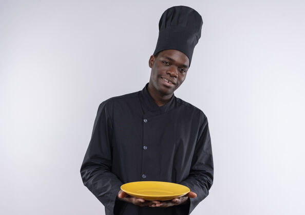 请年轻的美籍黑人厨师身着厨师制服 双手拿着盘子 上面有白色的复印空间年轻复制制服