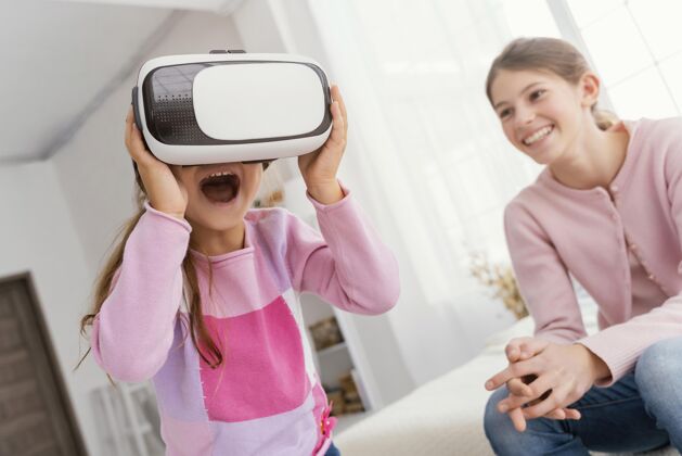 家庭两姐妹在家玩虚拟现实耳机乐趣在一起娱乐