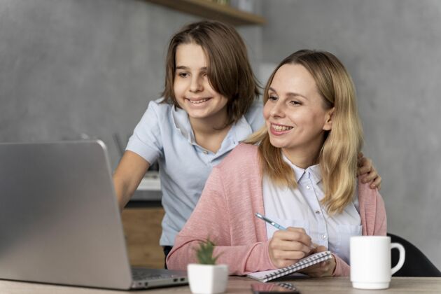 女孩在笔记本电脑上工作的女人和女孩孩子女人钢笔