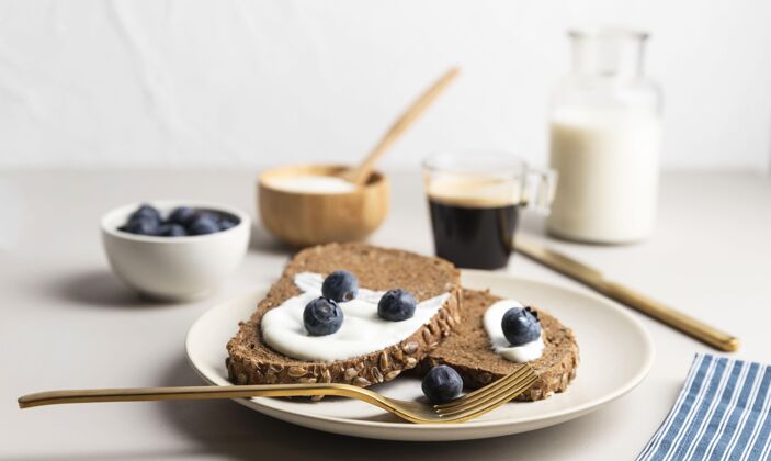 烹饪高角度的烤面包放在盘子里 配上蓝莓和牛奶液体切片早餐