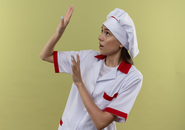 空间年轻吓坏了的穿着厨师制服的白人厨师女孩假装用手防守 看着绿色的一面 留着复制空间手绿色厨师