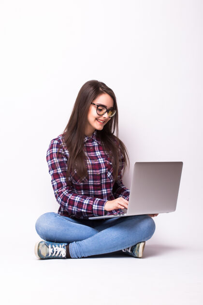 年轻人在白色背景的地板上操作笔记本电脑的年轻女子黑发学习白色