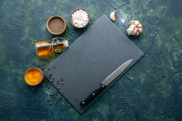 胡椒顶视图不同的调味料用油刀在深蓝色的背景上食用香料胡椒菜晚餐肉色盐烤刀肉容器