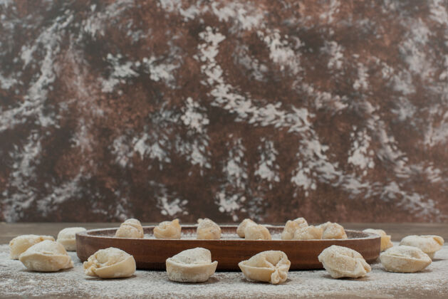 美味生饺子在木板上加面粉食物木头好吃
