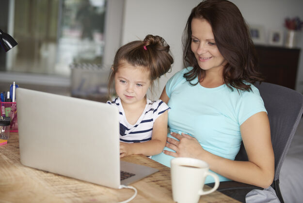 室内女儿和母亲使用电脑技术债券使用电脑怀孕