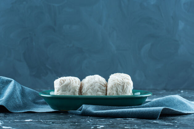 糖传统的土耳其棉花糖放在毛巾上的盘子里 蓝色背景美味美味美味
