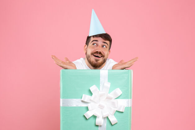 前面正面图：年轻男性站在礼品盒内的粉色圣诞照片情感真人颜色庆祝礼物