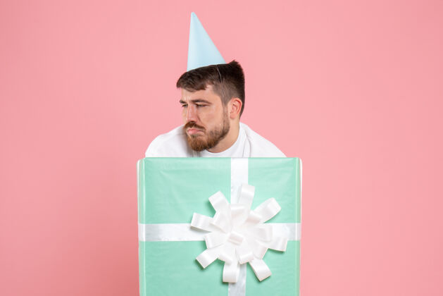 礼物正面图年轻男性站在礼物盒内粉色睡衣派对照片情感睡眠人类里面盒子睡眠