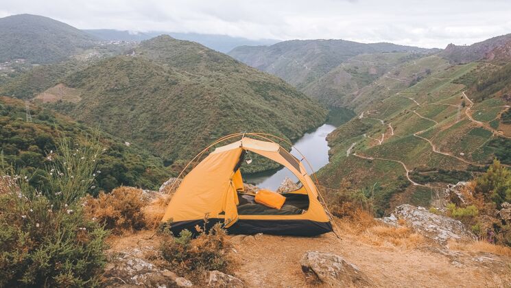 峡谷西班牙西尔峡谷的黄色帐篷日落山悬崖
