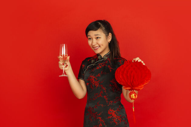 愿望年轻的亚洲女人喝香槟拿着灯笼女性手服饰