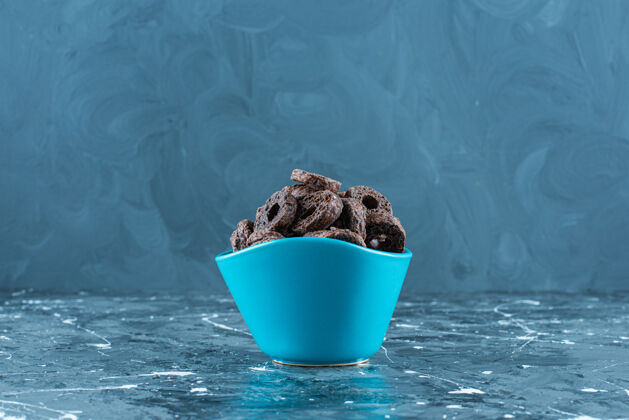 牙套美味的巧克力涂层玉米圈在一个碗里 在大理石背景上可口风味玉米圈
