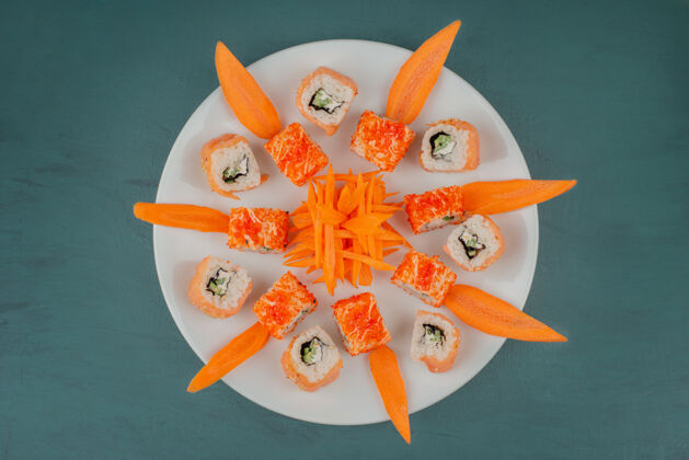 鱼把寿司和胡萝卜片放在白色盘子里寿司食物胡萝卜