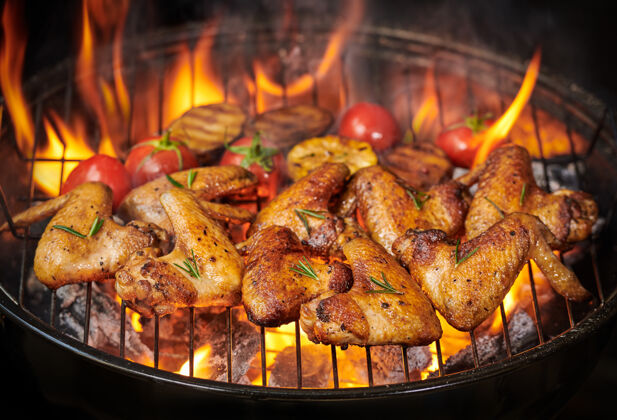 膳食烤鸡翅放在火红的烤架上 烤蔬菜放在烤肉酱里 胡椒籽 迷迭香 盐顶视图有复印空间红吸烟午餐