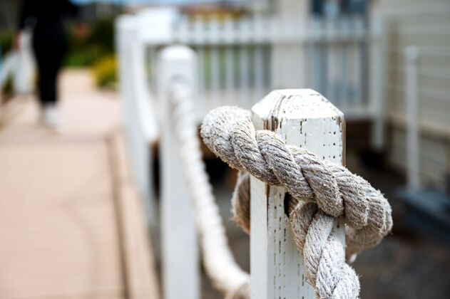 船选择性聚焦特写镜头的绳子绑在木柱从一个旧灯塔棕色焦点海岸